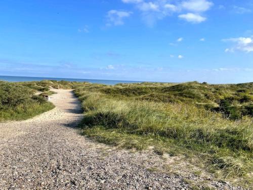 a gravel path on a beach near the ocean at 6 person holiday home in Brovst-By Traum in Brovst