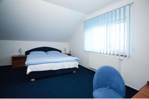 1 dormitorio con 1 cama y alfombra azul en Hotel U Jelena en Havířov