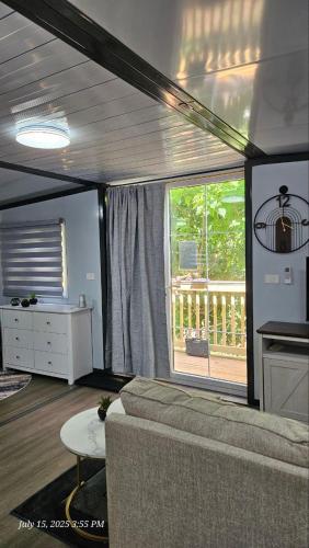 a living room with a couch and a large window at Cozy Foldable Container Pipestem Getaway For 2 in Pipestem