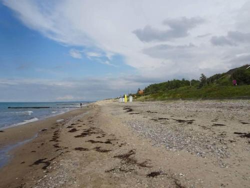 a beach with footprints in the sand and the ocean at 4 person holiday home in Græsted-By Traum in Græsted