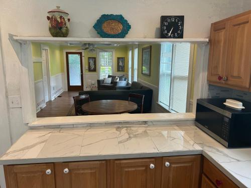 a kitchen with a table and a living room at 2br 2ba Close to Downtown, Midtown, and FSU in Tallahassee