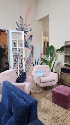 a living room with couches and chairs and a mural at Mandioca Hostel in Asuncion