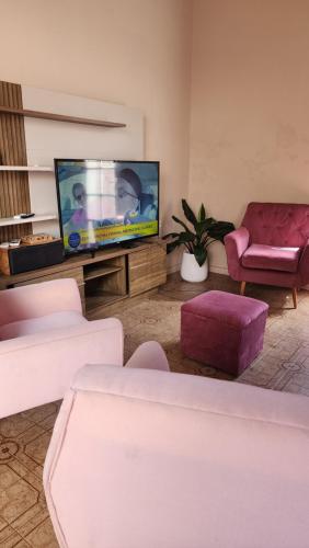 a living room with couches and a flat screen tv at Mandioca Hostel in Asuncion