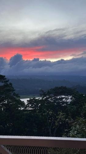 a sunset with a view of a river and trees at Quinta La Lomita in Turrialba