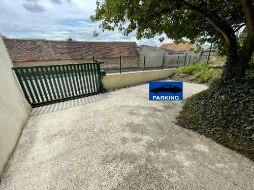 a parking sign sitting in the driveway of a house at Le Colibri in Vinneuf