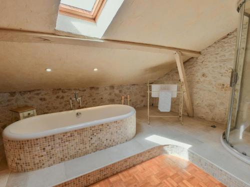 a bathroom with a bath tub in a attic at Les Roches de Roquecor in Roquecor
