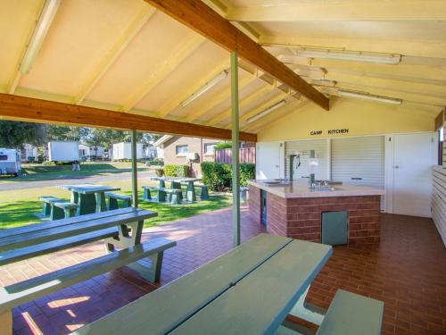 an outdoor patio with picnic tables and a bar at Toowoomba Caravan Park in Toowoomba