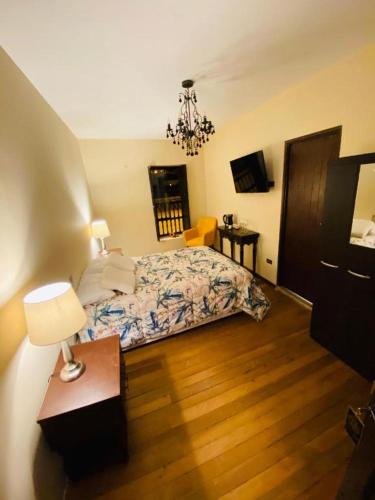 a bedroom with a bed and a table with a lamp at Casona Tupac Hotel Cusco in Cusco