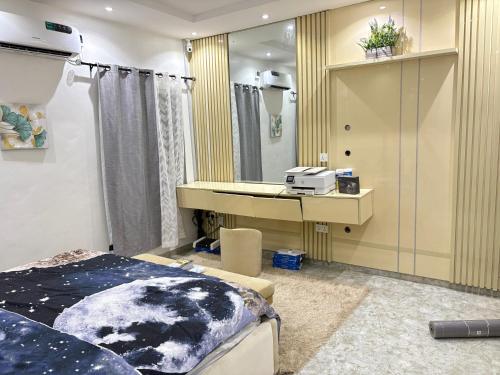 a bedroom with a bed and a desk and a mirror at Spacious elegant 3 Bedroom Bungalow in RCCG Camp Mowe WiFi AC Solar in Mowe