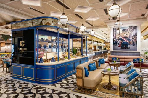 a lobby with a bar with couches and chairs at Londoner Grand, a Luxury Collection Hotel, Macau in Macau