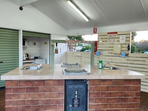 a large kitchen with three sinks in a room at Toowoomba Caravan Park in Toowoomba