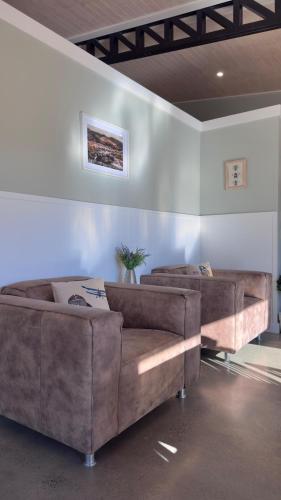 a living room with two brown couches in a room at Taupo s best lifestyle vacation in Taupo