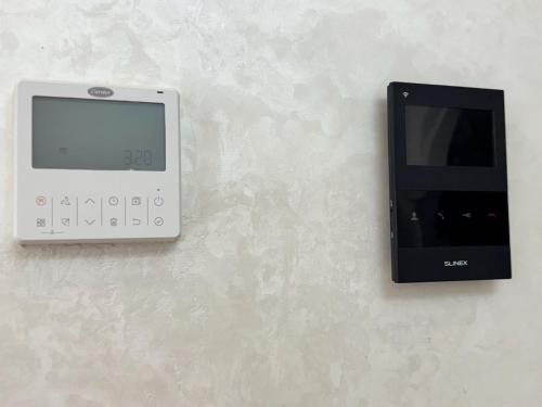 a digital clock on a wall next to a charger at Appartement élégant au cœur de Ain Hayani in Tangier