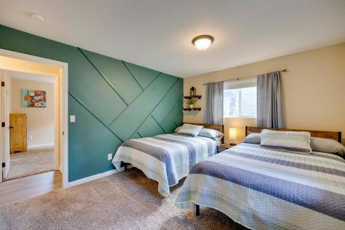 a bedroom with two beds and a green wall at Comforting Woodland Park Home with Fire Pit! in Woodland Park