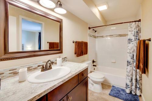 a bathroom with a sink and a toilet and a mirror at Comforting Woodland Park Home with Fire Pit! in Woodland Park