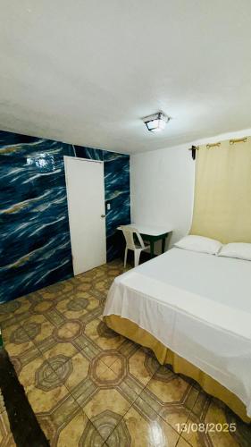 a bedroom with a bed and a painting on the wall at The Wave Hostel Corn Island in Corn Island