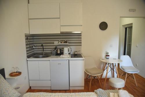 a kitchen with a sink and a table with chairs at Dekart 2 in Niš
