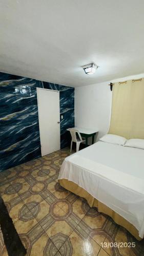 a bedroom with a bed and a painting on the wall at The Wave Hostel Corn Island in Corn Island