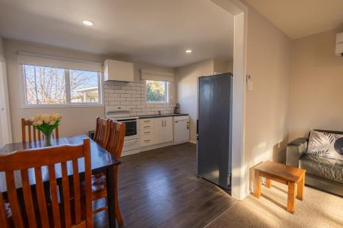 a kitchen and living room with a table and a refrigerator at Modernised Mackenzie with central location. in Twizel