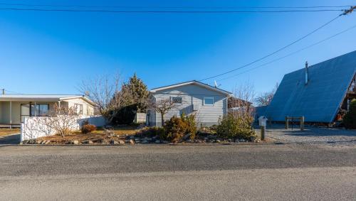 a house with a blue building next to a street at Modernised Mackenzie with central location. in Twizel