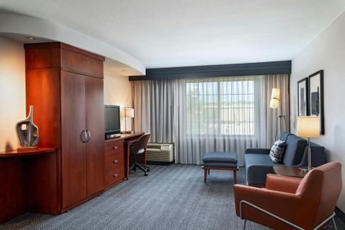 a hotel room with a couch and a desk at Courtyard by Marriott Omaha Aksarben Village in Omaha