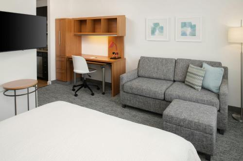 a hotel room with a bed and a couch and a desk at TownePlace Suites by Marriott Lancaster in Lancaster
