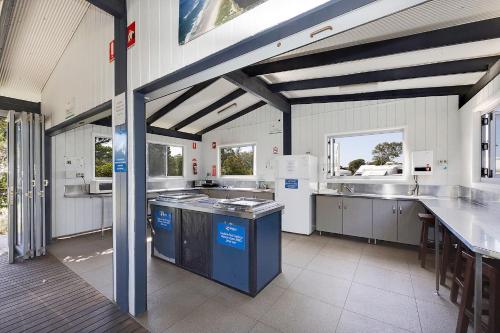 a large white kitchen with a large counter top at Reflections Lennox Head - Holiday Park in Lennox Head