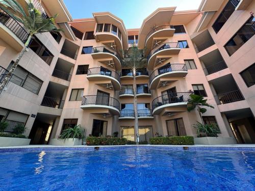 a large apartment building with a swimming pool in front of it at Monaco Condominiums, Jacó, Costa Rica - Luxury 3 Bedrooms in Jacó