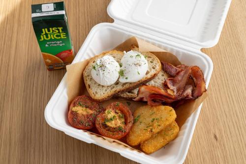 a lunch box with a sandwich and bacon and potatoes at Quest 256 Lambton in Wellington