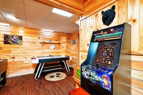 a game room with a pool table and a game machine at Wonderland Cabin in Sevierville