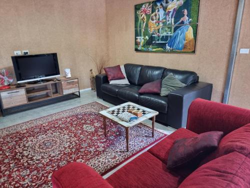 a living room with a couch and a tv at Barn at Ambrosia in Katikati
