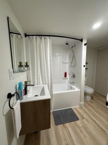 a bathroom with a tub and a sink and a toilet at Cozy Private Bachelor Unit King Size bed in Riverview