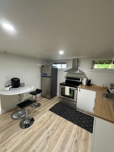 a kitchen with a stove and a counter with two stools at Cozy Private Bachelor Unit King Size bed in Riverview