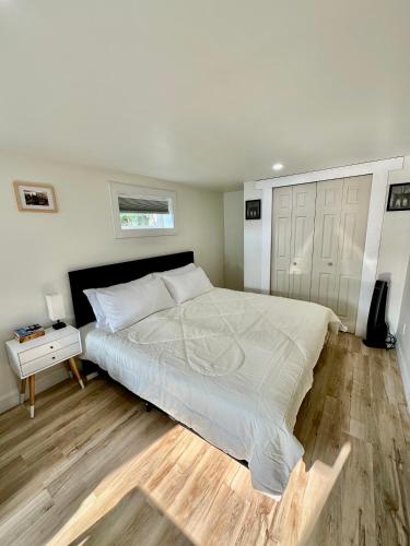 a bedroom with a large bed and a wooden floor at Cozy Private Bachelor Unit King Size bed in Riverview
