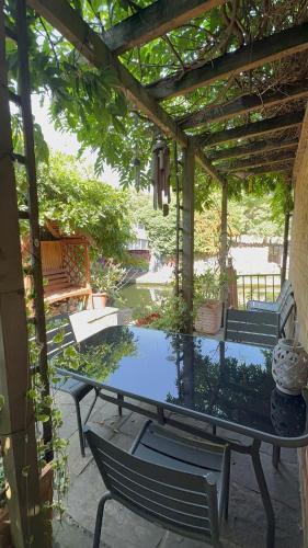a patio with a table and chairs under a pergola at Amazing Location - City of London- 2 Bedroom Stunning Canal View House With Private Garden,Parking & Balcony in London