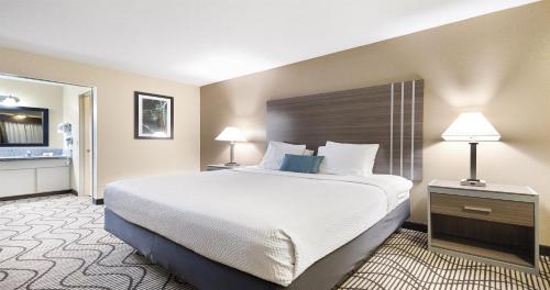 a hotel room with a large bed and two lamps at SureStay Plus Hotel by Best Western Sacramento North in Sacramento