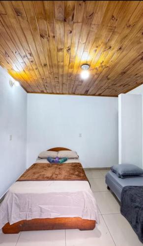ein Schlafzimmer mit einem Bett mit Holzdecke in der Unterkunft Chalet Amplio in Encarnación
