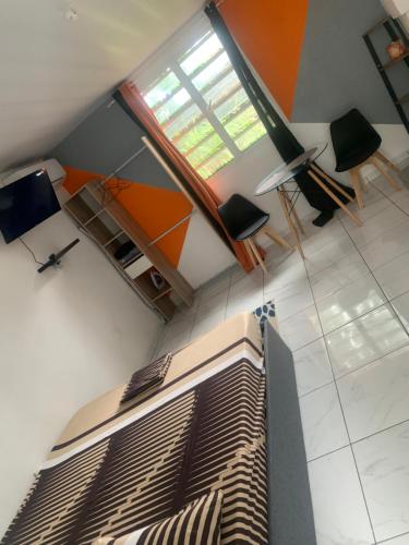 a living room with a bed and a window at Elkana in Montjoly