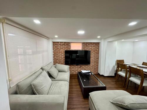 a living room with a couch and a tv at Maravilloso departamento en Azogues in Azogues