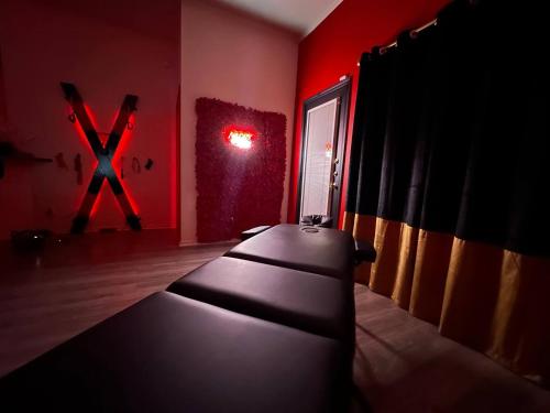 a room with a black couch in a red room at Red Chamber Tx King Spa & Couples Retreat in Killeen