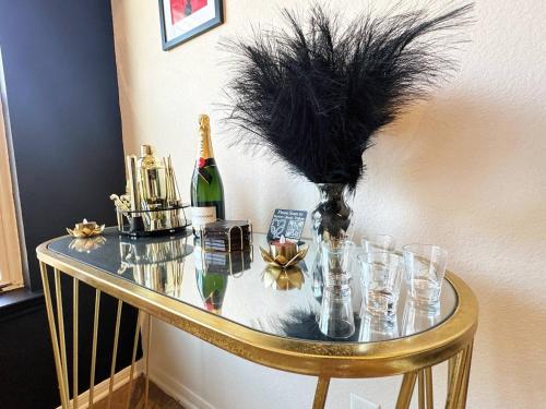 a glass table with glasses and a bottle of wine at Red Chamber Tx King Spa & Couples Retreat in Killeen