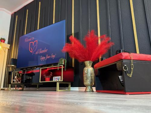 eine Vase mit roten Federn in einem Raum in der Unterkunft Red Chamber Tx King Spa & Couples Retreat in Killeen