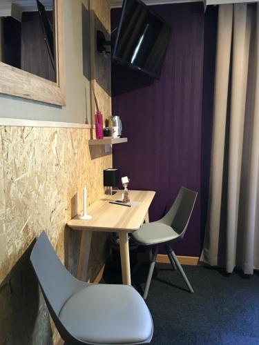 a small table and two chairs in a room at Hotel SPA Au Cheval Blanc in Ribeauvillé
