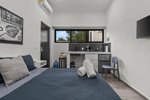 a bedroom with a bed with two white towels on it at Casona Santa Rita Bucerias in Bucerías