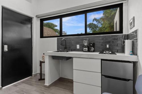 a kitchen with a sink and a window at Casona Santa Rita Bucerias in Bucerías