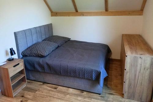 una camera con letto e comodino in legno di New, comfortable holiday home by the sea a Lędzin