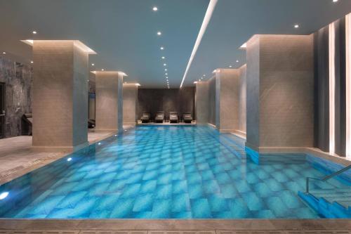 a swimming pool in a hotel with blue water at Izmir Marriott Hotel in Izmir
