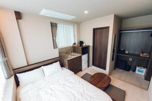 a bedroom with a bed and a table in it at MONTHLIV Gwangjang Market Hotel Stay in Seoul