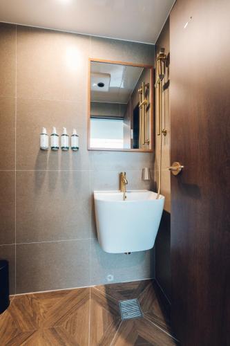 a bathroom with a white sink and a mirror at MONTHLIV Gwangjang Market Hotel Stay in Seoul