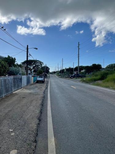 an empty road with a car parked on the side at Combate el Carribe Paradise in Cabo Rojo
